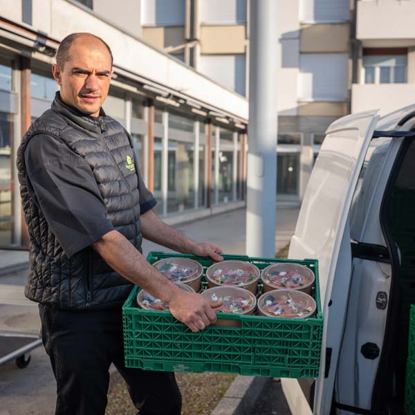 Un cuisinier charge une livraison de repas