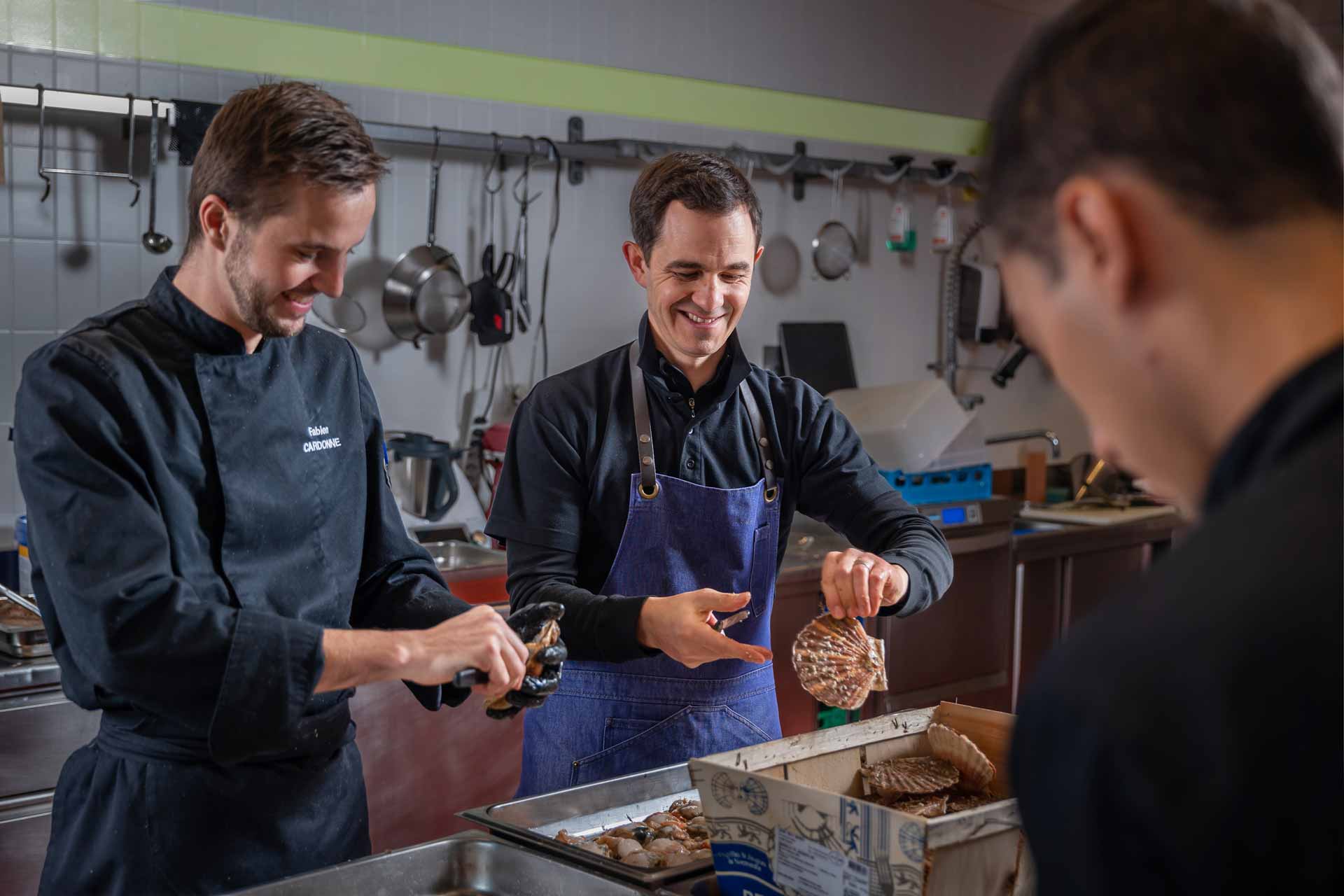 Deux cuisiniers dressent des plats en cuisine